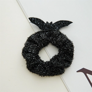 Detail of Halloween black scrunchie with glitter fabric and glossy bat wings decoration