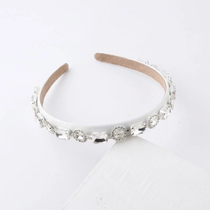 Detail of white crystal headband with prong-set rhinestones and non-slip lining