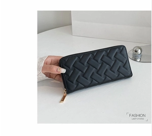 Detail of black woven leather texture on long zipper wallet with decorative metal ball charm
