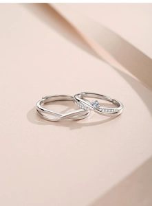 Macro detail of silver Mobius couple rings with sparkling zircon on soft pink background