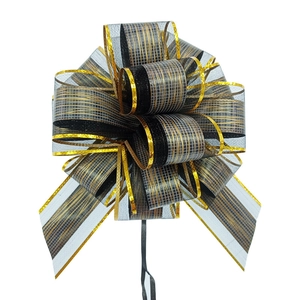 Detail of a large black and gold striped ribbon bow with metallic edges and wood grain texture