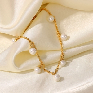 Elegant 18K gold-plated anklet with white pearl pendants on champagne silk background