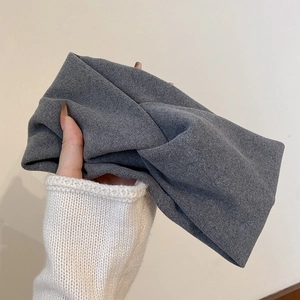 Detail eines weichen grauen beflockten Stirnbands aus flauschigem Samtstoff in der Hand