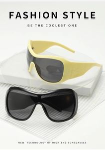 Detailed view of oversized Y2K shield sunglasses in black and pale yellow frames