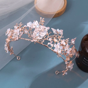 Detail of rose gold bridal tiara with intricate butterfly, floral motifs and sparkling rhinestones
