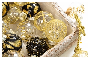 Detail of luxury gold and black Christmas balls with glitter patterns in a wooden basket