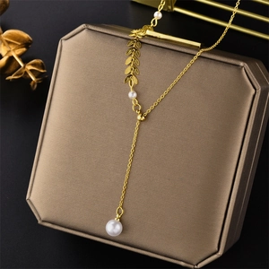 Golden leaf wheat spike necklace with pearl pendant in Y-shape on jewelry box