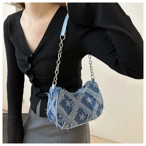 Star pattern denim crossbody bag with silver chain strap shown on model's shoulder