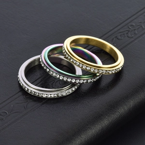 Close-up of three rotating stainless steel rings with full pavé stones on black leather