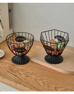 Close-up of black iron wire coffee pod holders with Coffee logo on a wooden countertop