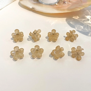 Detailed set of eight mini resin flower hair claws in amber and cream tones