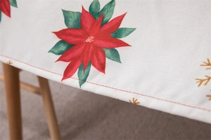 Detailed view of poinsettia and golden snowflake print on textured waterproof tablecloth