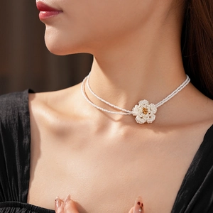 Close-up of elegant multi-layer pearl necklace with a vintage camellia flower pendant