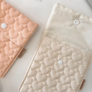 Detailed close-up of quilted heart pattern and button closure on small fabric bags