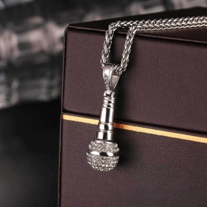 Close-up of a silver microphone pendant necklace with pavé cubic zirconia accents