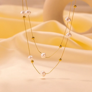 Double-layered gold chain necklace with baroque pearls and gold beads in vintage style