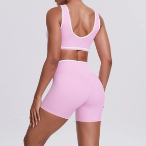 Detailed back view of pink yoga set showing criss-cross waist and contrast white piping