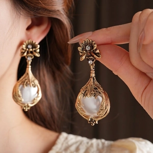 Vintage gold floral earrings with white resin pearls and crystals in a retro style