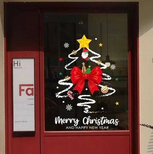Close-up of festive window stickers with Merry Christmas lettering and white tree design