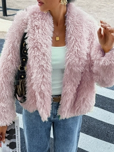 Detail of pink faux fur texture on a cropped jacket shown in a stylish urban setting