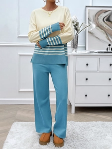 Detail of knit beige top with blue stripes on cuffs and hem matching wide leg pants