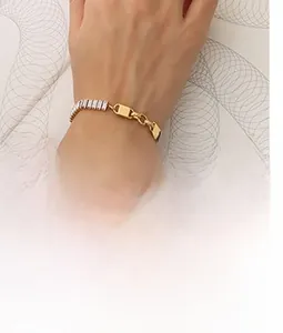 Detailed close-up of a double-layered gold chain bracelet with rectangle crystal inlay