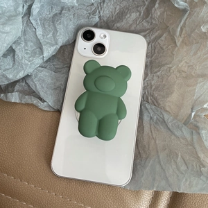 Macro view of matte forest green 3D bear phone grip on a white smartphone back