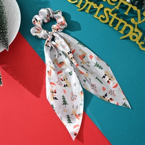 Macro detail of silk scrunchie with Christmas patterns on festive red and green background