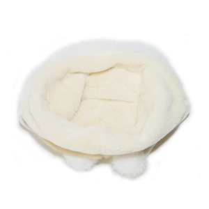 Detailed view of plush white winter hat featuring fluffy faux fur texture and pom-pom decor