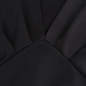 Details des eleganten schwarzen Satin-Midikleids mit Mesh-Einsatz und Plissee-Struktur