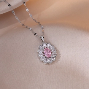 Macro shot of a floral necklace pendant with pink center stone and white zircon petals