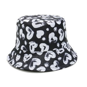 Close-up of black canvas bucket hat with white hand-drawn heart and dot prints