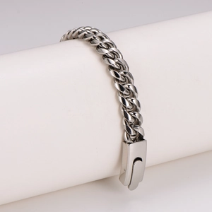 Polished stainless steel curb chain bracelet with snap clasp for men on white stand