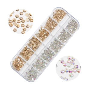 Detailed macro view of 12-grid box with mixed size gold and AB crystal nail art rhinestones