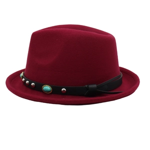 Close-up of burgundy fedora hat with turquoise stones and silver studs on a leather band