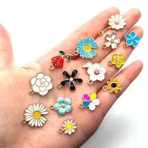 Mix of colorful enamel flower charms in palm, showcasing DIY alloy pendant varieties