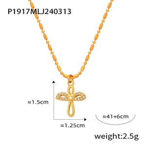 Macro detail of 18K gold-plated cross pendant with heart center and pavé zircon stones