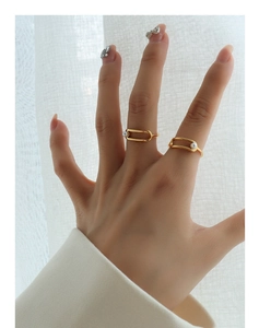 Detail of geometric gold-plated rings with pearls on elegant white backdrop