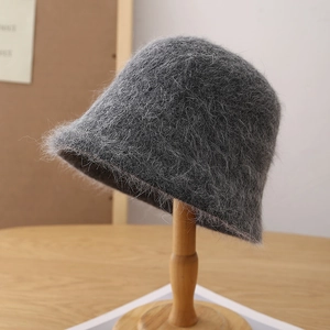 Close-up of grey angora wool blend bucket hat texture on a wooden stand