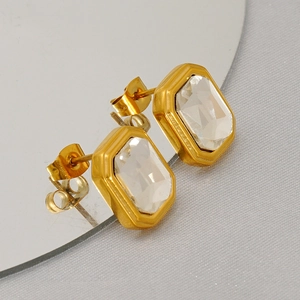 Boucles d'oreilles rectangulaires dorées avec zircons clairs sur un support miroir chic