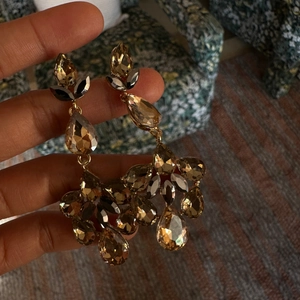 Detailed view of long waterdrop tassel earrings with champagne and grey crystals