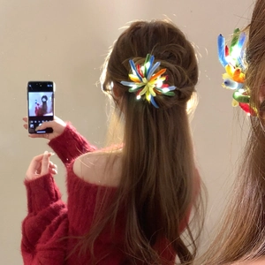 Close-up of a colorful glowing fiber optic flower hair clip worn on dark wavy hair