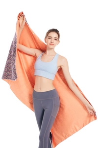 Detail of vibrant orange microfiber beach towel featuring paisley patterns and snap buttons
