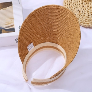 Detailed macro view of woven paper sun hat showing interior wash label and 100% paper tag