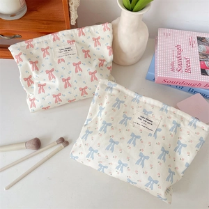 Close-up of floral and bow printed cotton fabric cosmetic bags in a cozy home setting