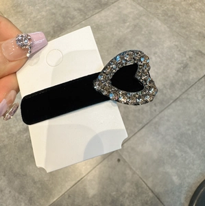 Dettaglio dell'elegante fermaglio per capelli in velluto nero con cuore di strass lucidi