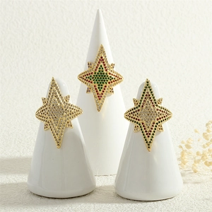 Detailed shot of star-shaped gold rings inlaid with colorful zircon on display stands