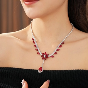 Detail of a vintage silver necklace with red zircon floral design and a teardrop pendant