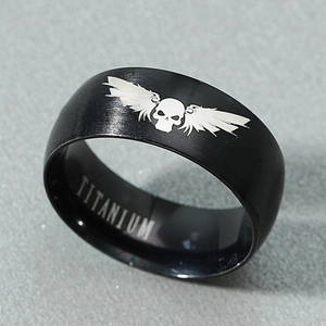 Gothic black titanium ring featuring skull and wings engraving from a 45-degree angle