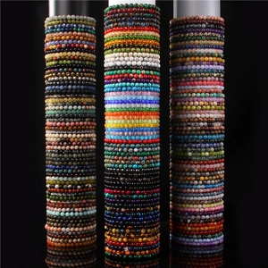 Close-up of assorted 6mm natural stone beaded bracelets on vertical display stands